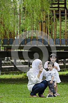 Young parents spending time with their children at park during weekend