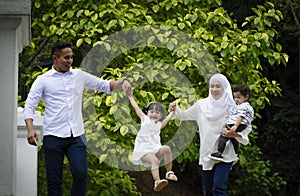 Young parents spending time with their children at park during weekend