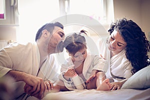 Young parents with their little girl after bath.