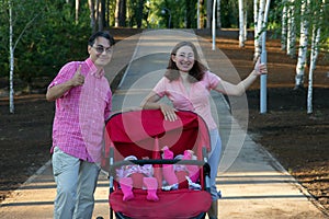 Young parents and their two little children in a twin stroller