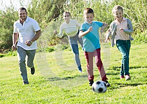 Young parents with two children playing soccer