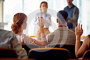 Young participants having questions during a business lecture in the conference room. Business, people, meeting, company