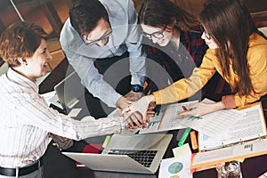 Young partners make an agreements about joint project. Group of coworkers working together ÃÂ¾n project in loft office photo