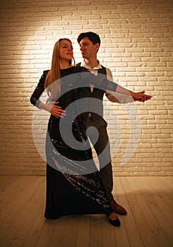 Young passionate dancing couple in love in classic style in studio ballroom