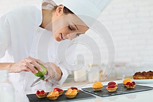 Young pastry cook preparing desert