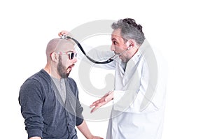 Young patient acting foolish during head examination photo