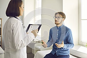 Young patient having conversation with physician during medical checkup at hospital