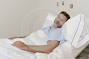 Young patient man lying at hospital bed resting tired looking sad and depressed worried