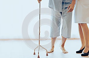Young patient man uses walking stick due to muscle severe weakness, numbness and tingling at his toes after getting vaccination.