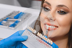 Young patient selects tooth color, crown, veneer, concept of medicine, dentistry and health photo