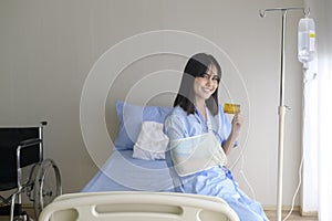 Young patient woman is holding credit card , admitting in hospital , Health care  concept photo