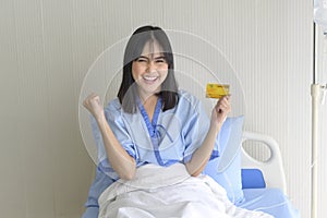 Young patient woman is holding credit card , admitting in hospital , Health care  concept