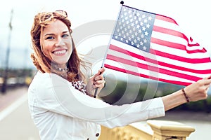 Young patriot woman with toothy smile stretching star spangled banner