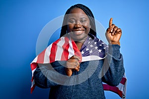 Young patriotic african american plus size woman with braids wearing united states flag surprised with an idea or question