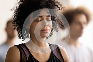 Young peaceful african american woman enjoying deep meditation.