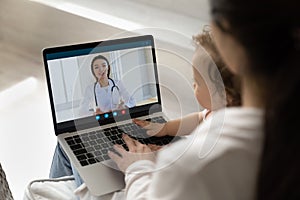 Young pediatrician giving consultation to new mom from laptop screen