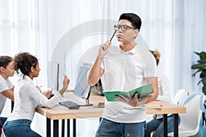 young pensive asian student boy in classroom