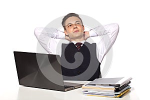 Young pensive businessman calculates taxes at desk in office.  on white