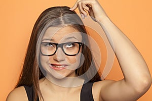 Young pensive girl scratching her head