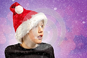 Young pensive looking boy with Christmas cap and winter atmosphere