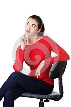 Young pensive student woman siting on armchair