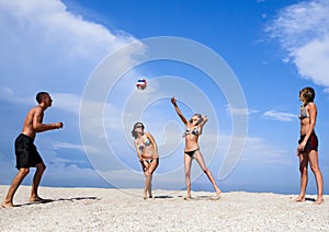 Young people on the beach playing volleyball