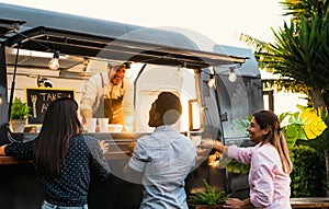 Young people buying meal from street food truck