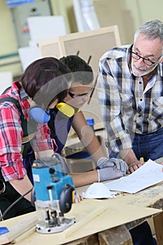 Young people in carpentry training with professor