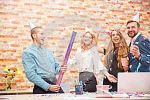 Young people celebrate something at a corporate party in the office