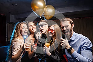 Young people celebrating birthday in karaoke bar