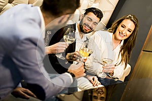 Young people celebrating and toasting with white wine