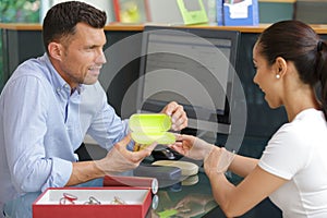 young people choosing glasses in optics store