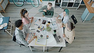 Young people colleagues doing high-five during business meeting in creative office