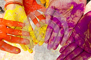 Young people with colorful powder in hands at holi festival in India celebrated with different colors. Holi hands, colorful hands