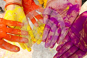 Young people with colorful powder in hands at holi festival in India celebrated with different colors. Holi hands, colorful hands