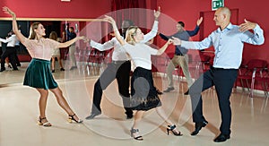 Young people dancing lindy hop in pairs in modern dance hall