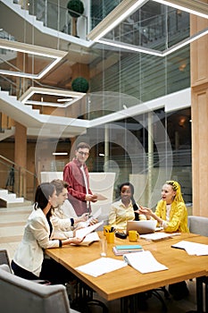 Young people discussing a book, checking bills