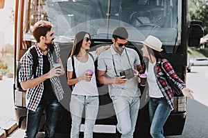 Young People Drinking Coffe in front of Tour Bus