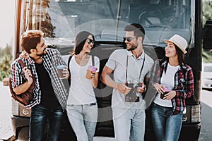 Young People Drinking Coffe in front of Tour Bus