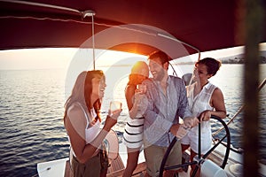 Young people drinking on a yacht and enjoying at vacation and luxury travel at sunset