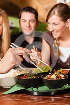 Young people eating in Thai restaurant