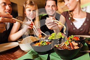 Young people eating in Thai restaurant