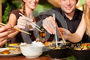 Young people eating in Thai restaurant