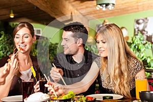 Young people eating in Thai restaurant