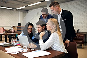 Young people in elegant suits working with laptop in the mordern room