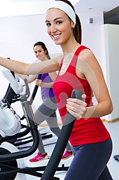 Young people with elliptic machine in the gym