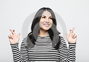 Young people, emotion and lifestyle concept: brunette woman made a wish and crossed her fingers