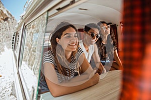 Young people enjoy holiday inside retro van