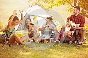 Young people enjoy in music of drums and guitar on camping trip