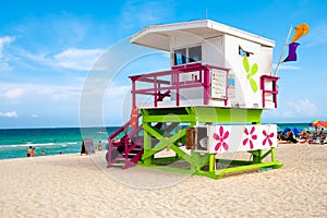 Young people enjoying the beach next to a colorful lifeguard tow